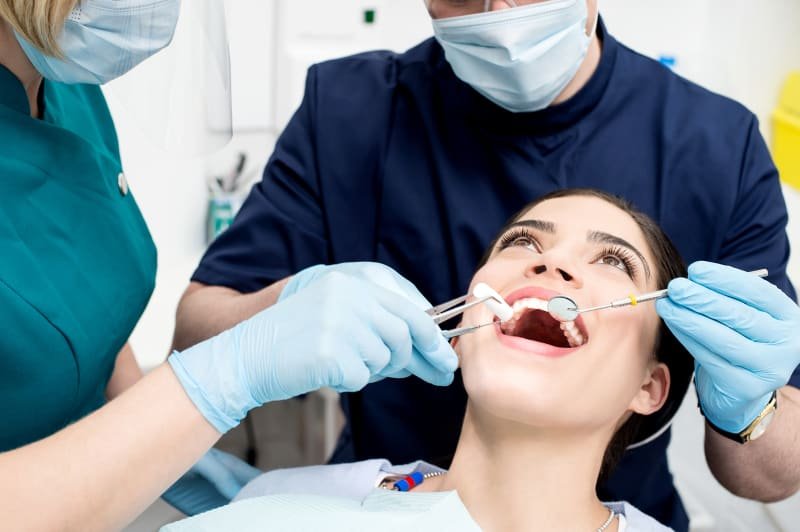 Dentist performing a thorough oral examination on a patient at Dr. Pawar's Advanced Dentistry