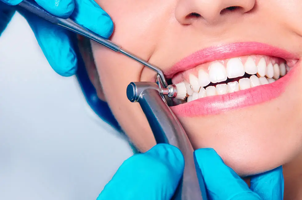 Dentist performing teeth cleaning and polishing procedure on a patient in Thane West.